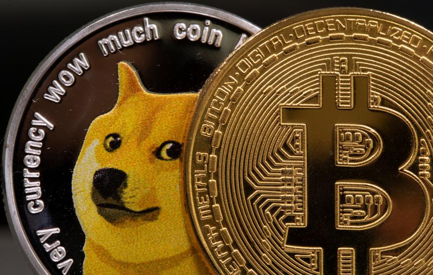 Representations of the virtual currency Dogecoin and Bitcoin are seen in this illustration taken June 16, 2021. REUTERS/Dado Ruvic/Illustration
