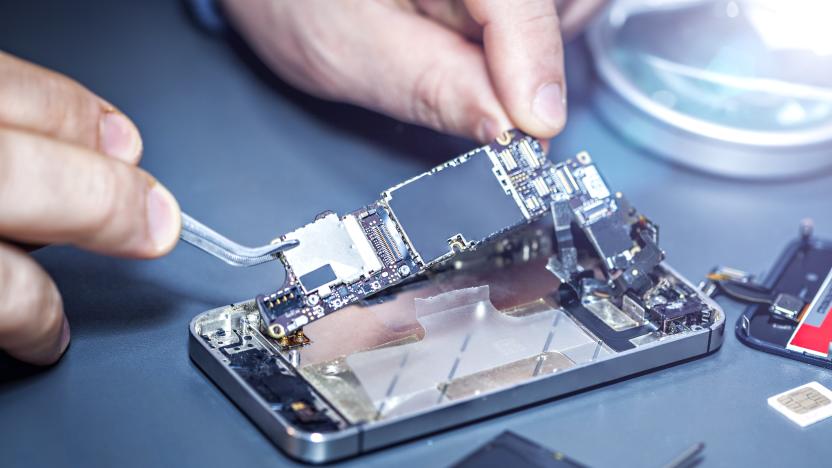 Technician repairs the damaged mobile phone. Serviceman is repairing a damaged cell phone. Technician repairs the damaged smartphone. Replacing the smartphone's motherboard.