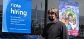 A pedestrian walks by a "now hiring" sign at Ross Dress ror Less store. (Getty Images)