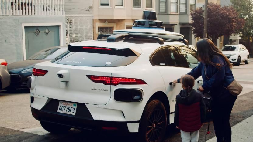 A woman and child stepping into an autonomous Waymo car