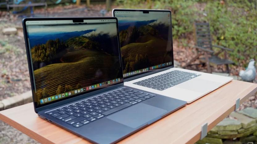 Two laptops on a table outside. 