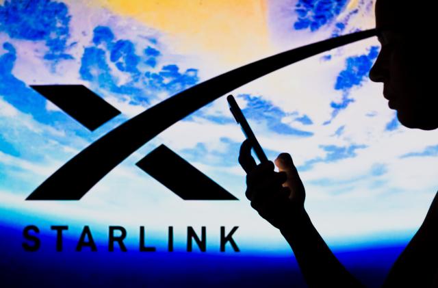 BRAZIL - 2022/05/02: In this photo illustration, the Starlink logo is seen in the background of a silhouetted woman holding a mobile phone. (Photo Illustration by Rafael Henrique/SOPA Images/LightRocket via Getty Images)