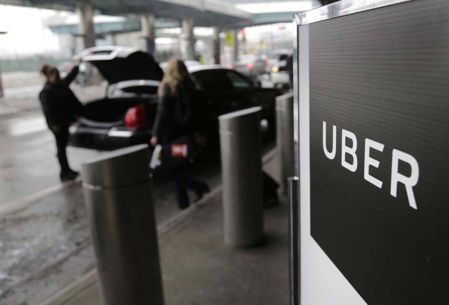 FILE - In this March 15, 2017, file photo, a sign marks a pick up point for the Uber car service at LaGuardia Airport in New York. Uber will resume testing autonomous vehicles in an area near Downtown Pittsburgh starting Thursday, Dec. 20, 2018. (AP Photo/Seth Wenig, File)