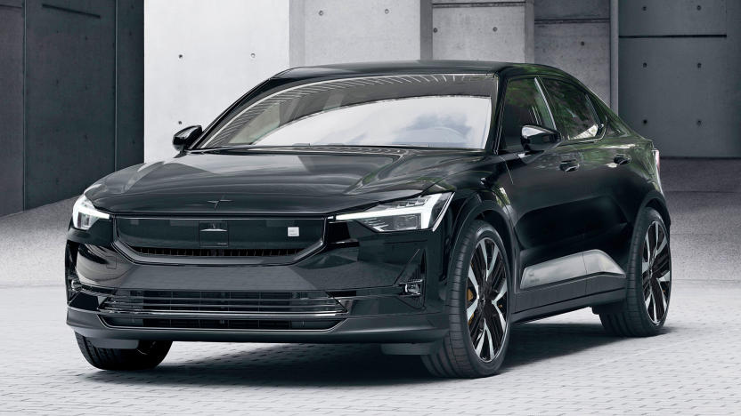 The 2024 Polestar 2 in black is seen parked in a cobbled lot with cement pillars behind hit.