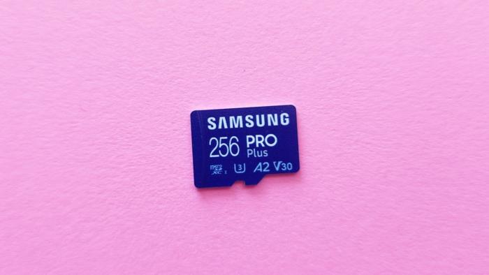 A blue Samsung Pro Plus 256GB microSD card rests against a pink background.