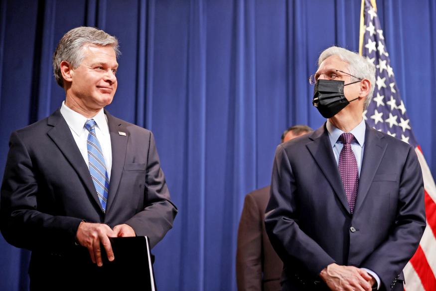 FBI Director Christopher Wray and U.S. Attorney General Merrick Garland face reporters as they announce charges against a suspect from Ukraine and a Russian national over a July ransomware attack on an American company, during a news conference at the Justice Department in Washington, U.S., November 8, 2021. 