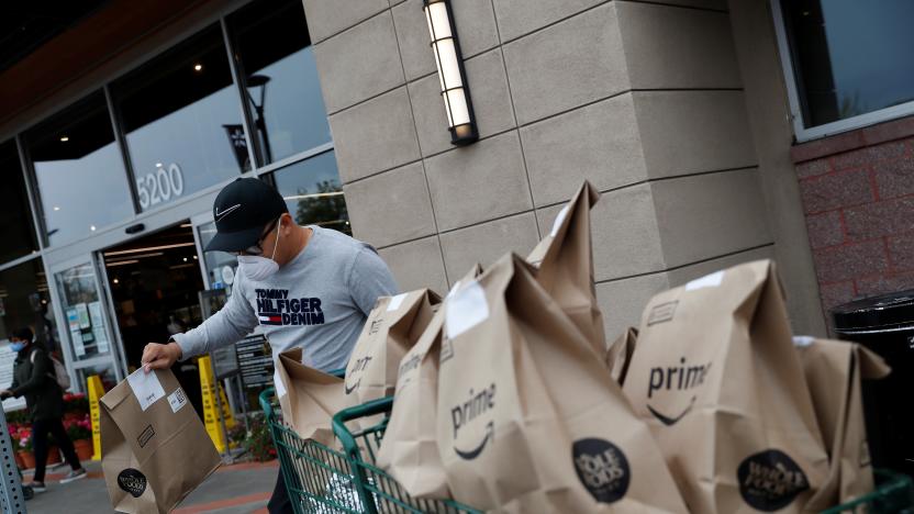 Excelso Sabulau, a 35-year-old independent contract delivery driver for Amazon Flex, wears a protective mask as he carries deliveries to his car near a Whole Foods Market, as spread of the coronavirus disease (COVID-19) continues, in Dublin, California, U.S., April 6, 2020. Picture taken April 6, 2020. REUTERS/Shannon Stapleton