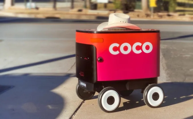 Coco delivery robot with a cowboy hat on top.