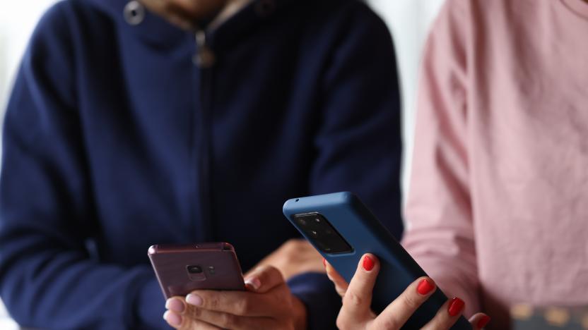 Two women are holding smartphones in their hands. Smartphone remote applications concept