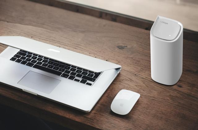 A router and a laptop on a desk.