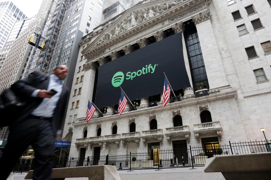 A Spotify banner adorns the facade of the New York Stock Exchange, Tuesday, April 3, 2018. Spotify, the No. 1 music streaming service which has drawn comparisons to Netflix, is about to find out how it plays on the stock market in an unusual IPO. (AP Photo/Richard Drew)