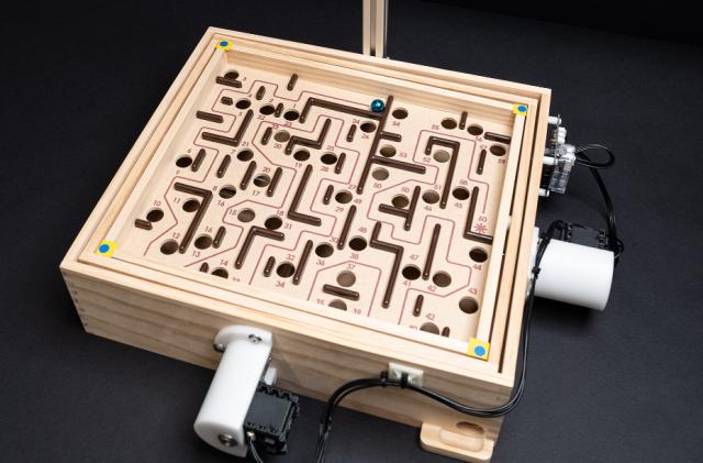 The marble game Labyrinth with motors atached to the dials.