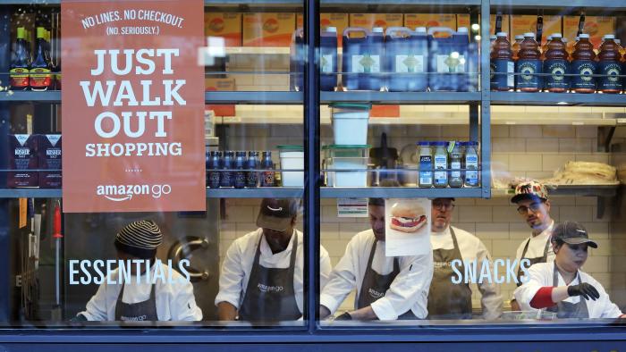 FILE - In this Jan. 22, 2018, file photo, workers as seen from a sidewalk window as they assemble sandwiches in an Amazon Go store in Seattle. A key executive behind Amazon Go, the online leader’s much heralded cashier-less grocery store, says she was surprised how many customers were hesitant to just walk out the store. (AP Photo/Elaine Thompson, File)