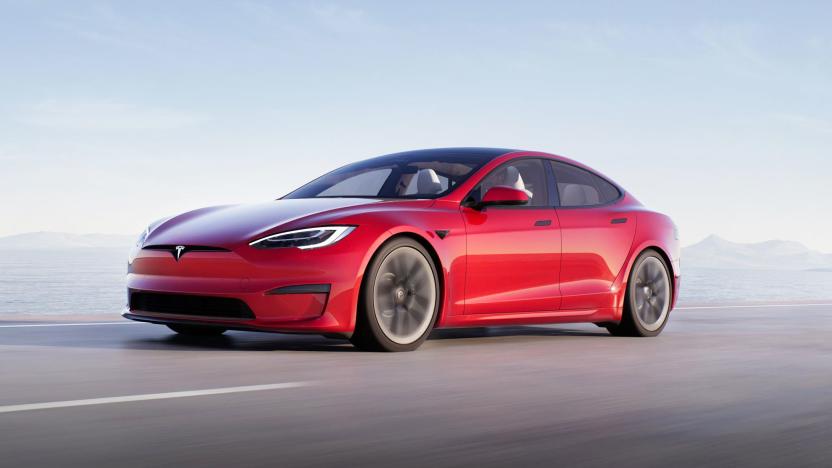 A Tesla Model S Plaid in red races down a coastal highway.