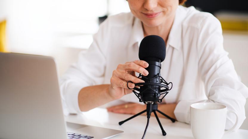 Female podcaster sitting at the table, talking on camera.