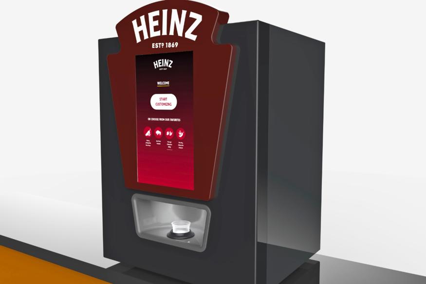 A computer rendering of the Heinz Remix sauce dispenser, showing a rectangular device with the Heinz logo at the top, four buttons on the front and a dispenser trough just below that.