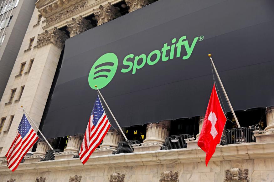 The Spotify logo hangs on the facade of the New York Stock Exchange with U.S. and a Swiss flag as the company lists it's stock with a direct listing in New York, U.S., April 3, 2018.  