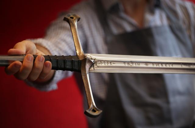 LONDON, ENGLAND - JULY 31:  A Bonhams employee holds 'Anduril' a prop sword belonging to Aragorn, hero of 'The Lord of the Rings' movie trilogy on July 31, 2014 in London, England. The sword, belonging to actor Sir Christopher Lee and estimated at $150,000-250,000, forms part of Bonhams 'There's No Place Like Hollywood' movie memorabilia auction taking place in New York on November 24, 2014.  (Photo by Peter Macdiarmid/Getty Images)