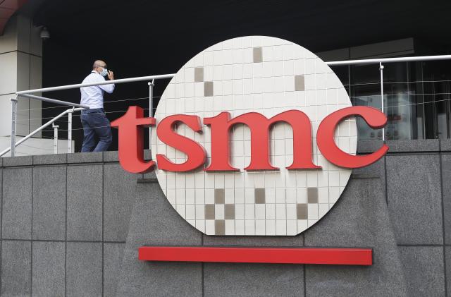 FILE - A person walks into the Taiwan Semiconductor Manufacturing Co., Ltd. (TSMC) headquarters in Hsinchu, Taiwan on Oct. 20, 2021. Taiwan Semiconductor Manufacturing Co., the biggest contract manufacturer of processor chips for smartphones and other products, said Thursday, Oct. 13, 2022, quarterly profit rose 79.7% over a year earlier to $8.8 billion amid surging demand. (AP Photo/Chiang Ying-ying, File)