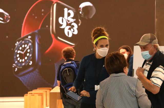 BEVERLY HILLS, CA - OCTOBER 08, 2020 - A customer service representative works with customers at the Apple store as shoppers return to indoor shopping after Los Angeles County eased restrictions at places like the Beverly Center in Beverly Hills on October 8, 2020. Such stores have been closed for weeks, but can reopen Wednesday at 25% capacity. The Beverly Center featured digital signage telling shoppers to wear a mask, wash their hands and to main social distance from each other while shopping. (Genaro Molina / Los Angeles Times via Getty Images)