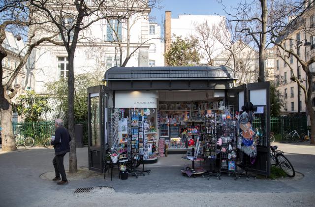 A picture taken on March 19, 2020, shows a man walking by a newspapers kiosk, in front of the Senate in Paris, on the third day of a strict lockdown in France to stop the spread of COVID-19, caused by the novel coronavirus. (Photo by Thomas SAMSON / AFP) (Photo by THOMAS SAMSON/AFP via Getty Images)