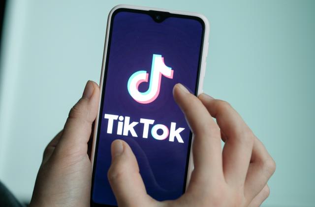 13 November 2019, Berlin: ILLUSTRATION - A girl is holding her smartphone with the logo of the short video app TikTok in her hands. With TikTok, users can create short mobile phone videos to music clips or other videos. Other users can comment on it, distribute hearts or react in any other way. Private messages are also possible. The app is particularly popular with young people. Photo: Jens Kalaene/dpa-Zentralbild/dpa (Photo by Jens Kalaene/picture alliance via Getty Images)