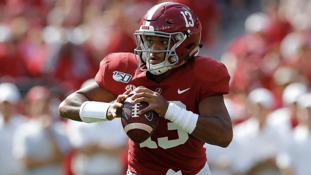 Tua Tagovailoa Alabama Crimson Tide Unsigned White Jersey Raising Up National Championship Trophy Photograph