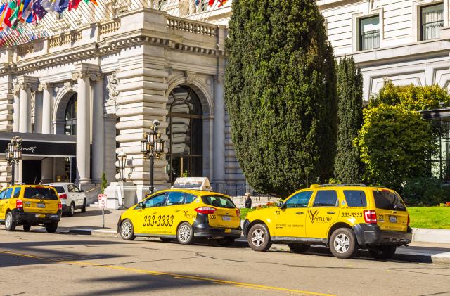 San Francisco, California, USA- 07 June 2015: Yellow taxi on Tony Bennett Way. Hotel Fairmont in the background.