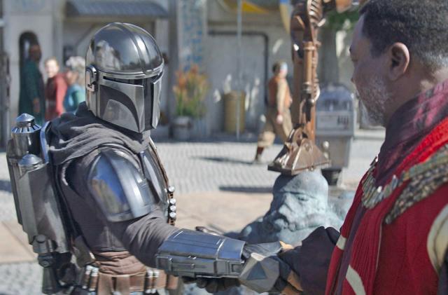 Din Djarin shakes hands with The Mandalorian in this scene from an episode of Season 3.