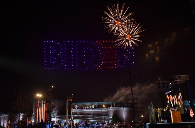 Fireworks are launched as illuminated drones spell BIDEN in the sky as US President-elect Joe Biden with his wife doctor Jill Biden alongside Vice President-elect Kamala Harris and her husband Douglas Emhoff and their families watch in Wilmington, Delaware, on November 7, 2020, after being declared the winners of the presidential election. - Democrat Joe Biden was declared winner of the US presidency November 7, defeating Donald Trump and ending an era that convulsed American politics, shocked the world and left the United States more divided than at any time in decades. (Photo by ANGELA  WEISS / AFP) (Photo by ANGELA  WEISS/AFP via Getty Images)