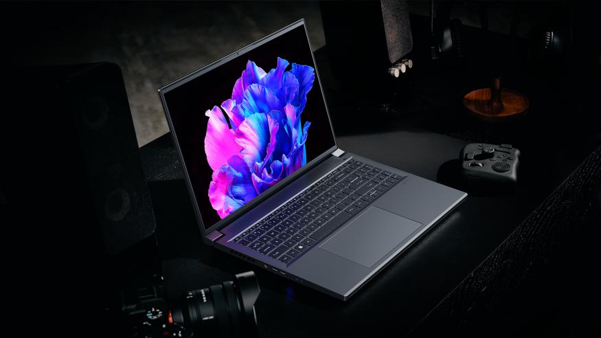 Acer Swift X 16 Promotional Image, with the Swift X sat on a dark table shrouded in darkness, the hint of a drone controller and a DSLR lurking in the gloom.
