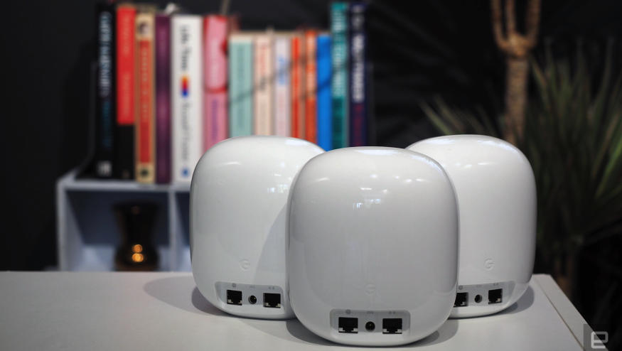 Image of three Nest WiFi Pro units, rear-on, in front of a blurred bookcase.