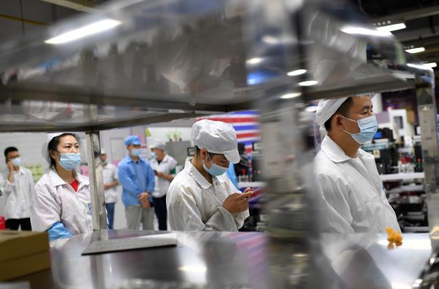 WUHAN, CHINA - AUGUST 05 2021: Workers in the Foxconn factory line up for the all-inclusive Covid-19 test in Wuhan in central China&#039;s Hubei province Thursday, Aug. 05, 2021. Forty-six spots of samples collection were set up across the compound of the electronics manufacturer to minimize the queuing time of the 20,000-plus workers. (Photo credit should read Feature China/Future Publishing via Getty Images)