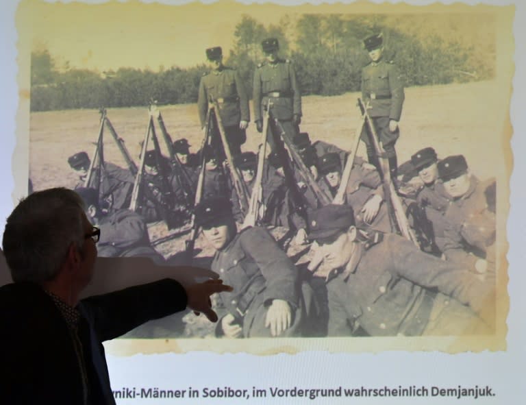 A staff member of the Topography of Terror archive points at a historical photograph allegedly showing convicted Nazi guard John Demjanjuk at the Sobibor camp (AFP Photo/Tobias SCHWARZ)