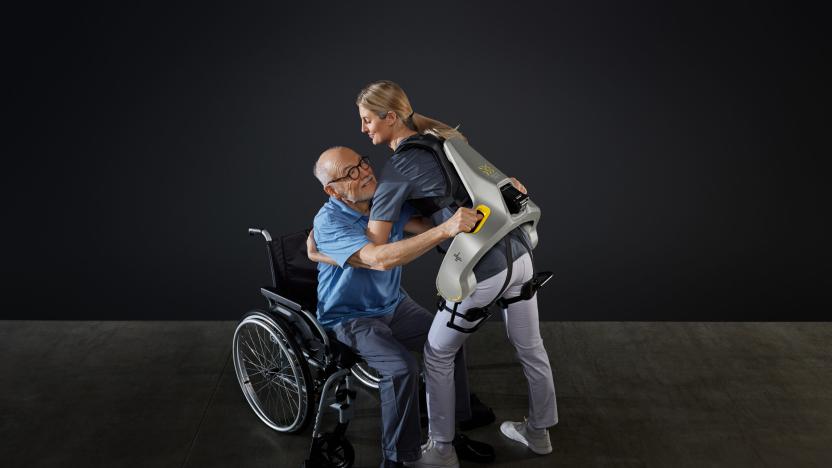 A nurse helping a patient while wearing an exosuit. 