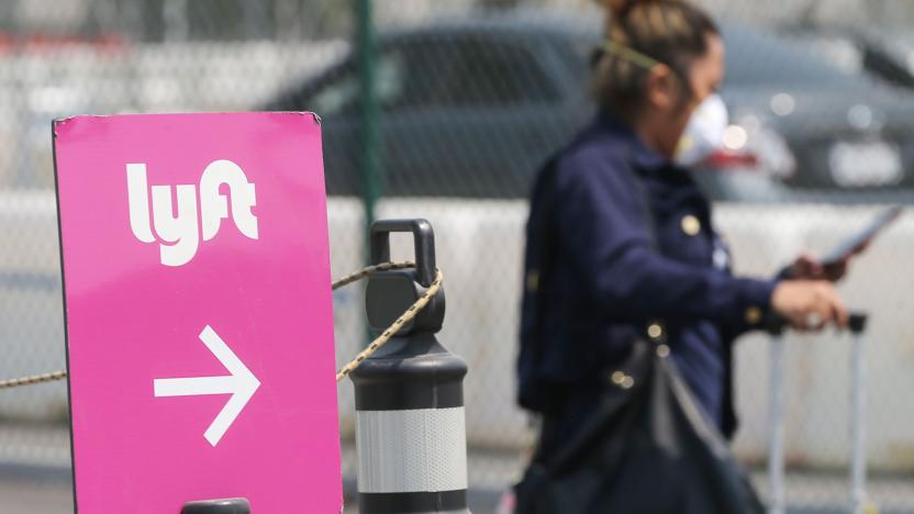 LOS ANGELES, CALIFORNIA - AUGUST 20: An air traveler walks toward a Lyft pickup area at Los Angeles International Airport (LAX) on August 20, 2020 in Los Angeles, California. Uber and Lyft drivers held a rally earlier at the airport calling for basic employment rights. An appeals court granted Lyft and Uber an emergency stay from needing to classify drivers as employees allowing ride-sharing services to continue after a threatened shutdown in California. (Photo by Mario Tama/Getty Images)