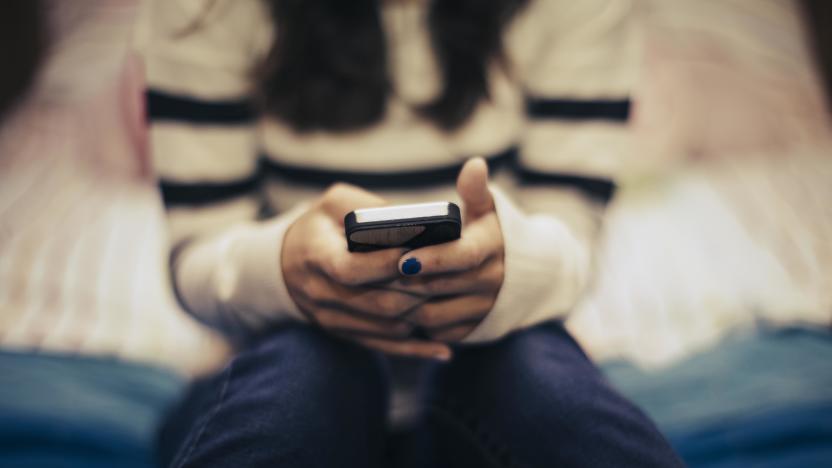 Close up of teenage girl in bedroom using smart phone