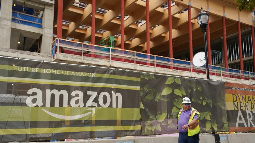 A construction worker passes a job site at Metropolitan Park, the first phase of new construction of Amazon's HQ2 development Arlington, Virginia October 13, 2021. REUTERS/Kevin Lamarque