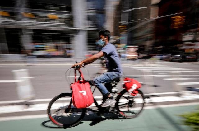 A rider for "Grubhub" food delivery service rides a bicycle during a delivery in midtown Manhattan following the outbreak of the coronavirus disease (COVID-19) in New York City, New York, U.S., July 9, 2020. REUTERS/Mike Segar