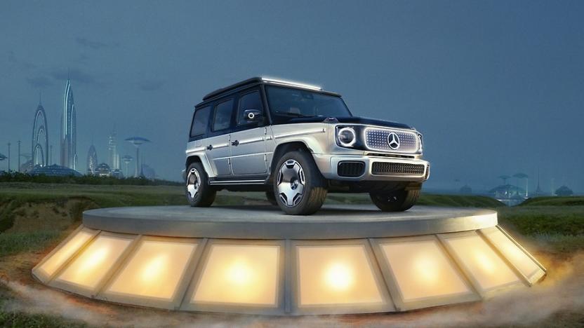 Mercedes-Benz electric G-Class concept vehicle, called the EQG, sits on an illumined podium. A futuristic city scape is in the distant background.