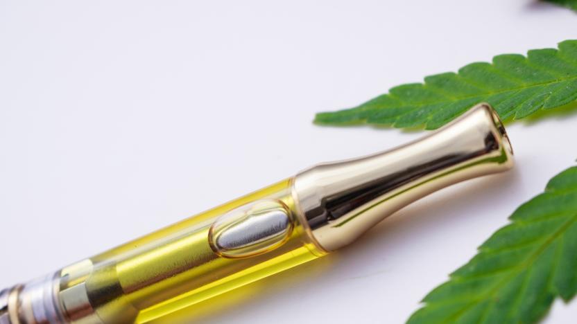 Full gram cartridge with cannabis oil and terpenes inside. With weed leaf on white background. An alternative method of smoking medical marijuana.