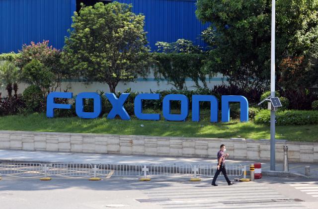 SHENZHEN, CHINA - SEPTEMBER 03 2022: A man passes by a compound of the electronics manufacturer Foxconn, which is under strict access control to prevent Covid-19, in Shenzhen in south China's Guangdong province Saturday, Sept. 03, 2022. (Photo credit should read AH CHI/ Feature China/Future Publishing via Getty Images)