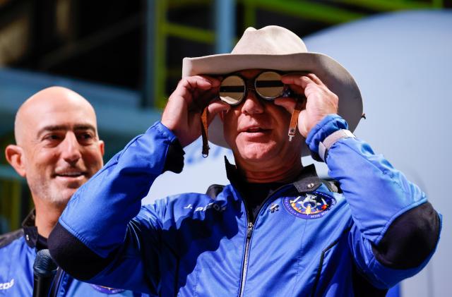 Billionaire American businessman Jeff Bezos wears goggles owned by Amelia Earhart which he carried into space at a post-launch press conference after he flew on Blue Origin's inaugural flight to the edge of space, in the nearby town of Van Horn, Texas, U.S., July 20, 2021. Bezos' brother Mark is on the left. REUTERS/Joe Skipper