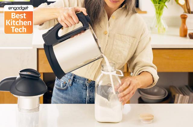 A women pouring plant milk out of the Almond Cow milk maker machine into a glass jug.