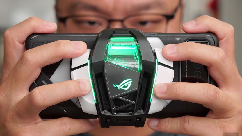 A person holding an ASUS ROG Phone 6 Pro with an AeroActive Cooler 6 mounted on the back.