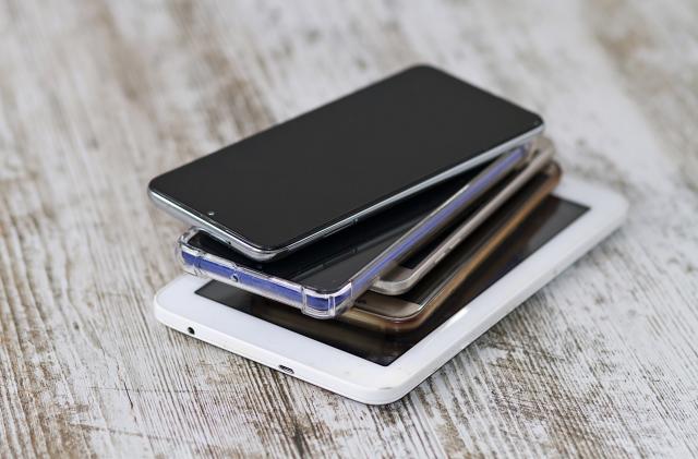 A smartphone pile and its charging and audio cables