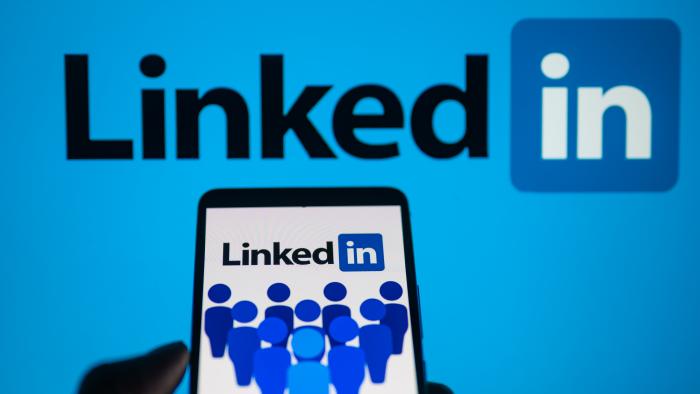 LinkedIn logo displayed on a smartphone with LinkedIn on screen seen in the background, in this photo illustration. On 16 October 2023, in Brussels, Belgium. (Photo by Jonathan Raa/NurPhoto via Getty Images)
