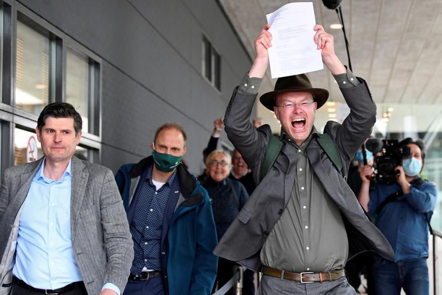 Donald Pols, Director of Milieudefensie (Friends of the Earth), reacts holding a copy of a verdict in a case brought on against Shell by environmentalist and human rights groups, including Greenpeace and Friends of the Earth, who demand the energy firm to cut its reliance on fossil fuels, in The Hague, Netherlands, May 26, 2021. REUTERS/Piroschka van de Wouw