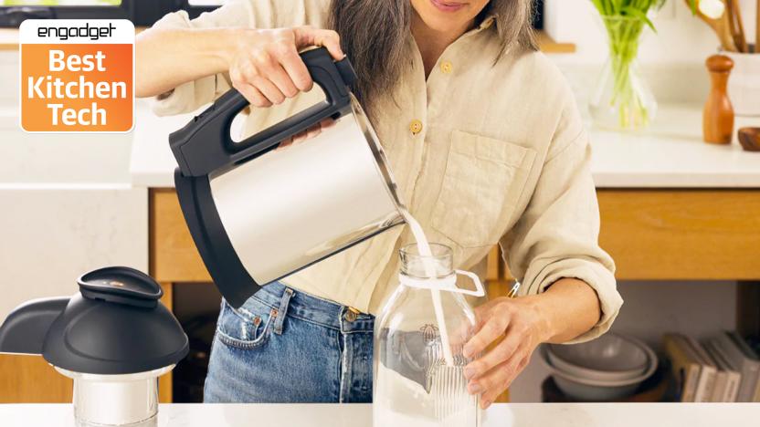 A women pouring plant milk out of the Almond Cow milk maker machine into a glass jug.