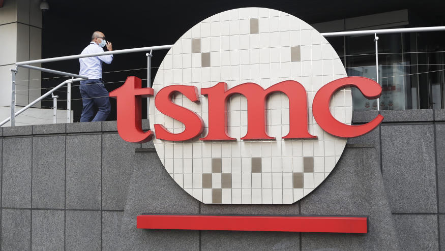 FILE - A person walks into the Taiwan Semiconductor Manufacturing Co., Ltd. (TSMC) headquarters in Hsinchu, Taiwan on Oct. 20, 2021. Taiwan Semiconductor Manufacturing Co., the biggest contract manufacturer of processor chips for smartphones and other products, said Thursday, Oct. 13, 2022, quarterly profit rose 79.7% over a year earlier to $8.8 billion amid surging demand. (AP Photo/Chiang Ying-ying, File)